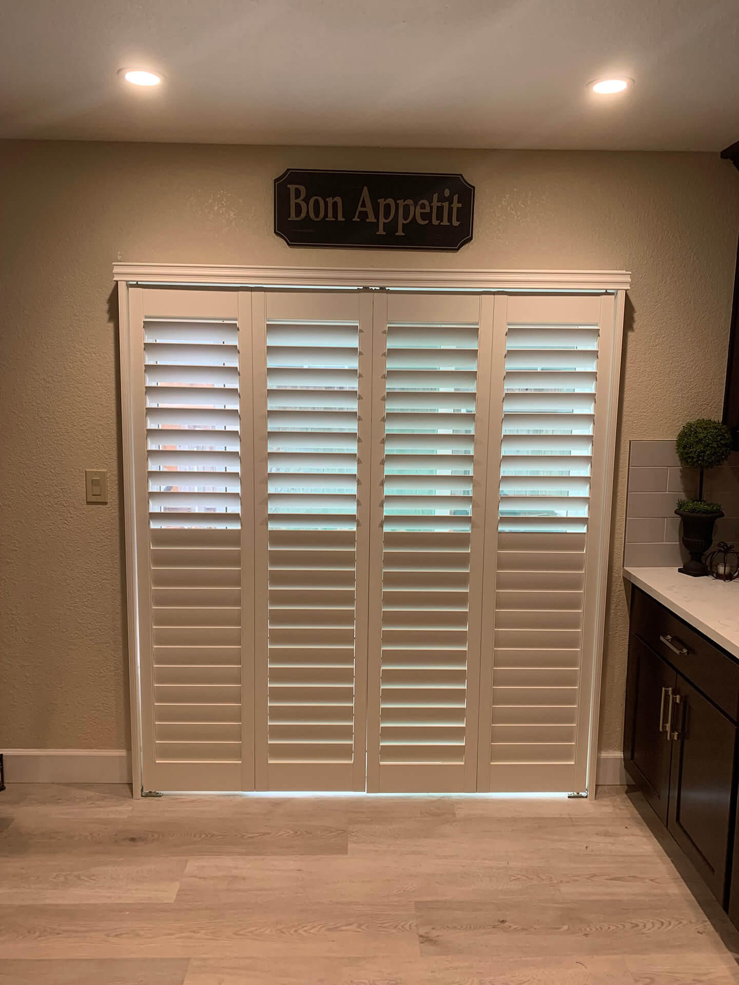 A large sliding door covered with shutters and a sign that says 'Bon Appetit' above the doors.