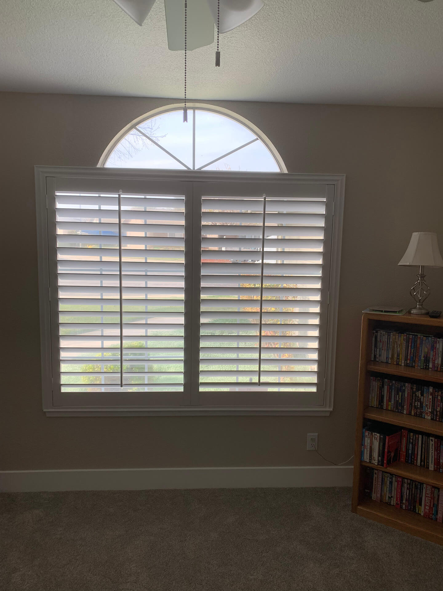 A home library with shutters covering the single window.