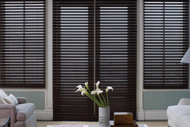 Brown wooden blinds covering windows and glass doors.