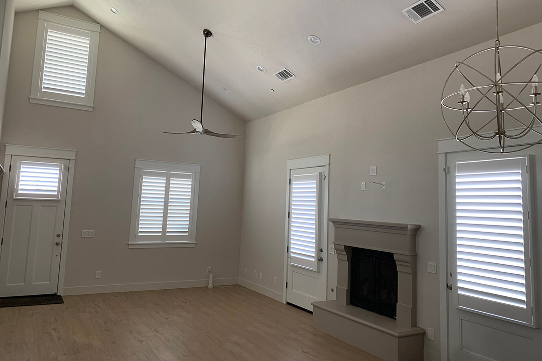 An empty living room with shutters covering every window.