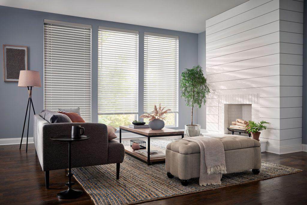 A blue and white living room with blinds covering tall windows.